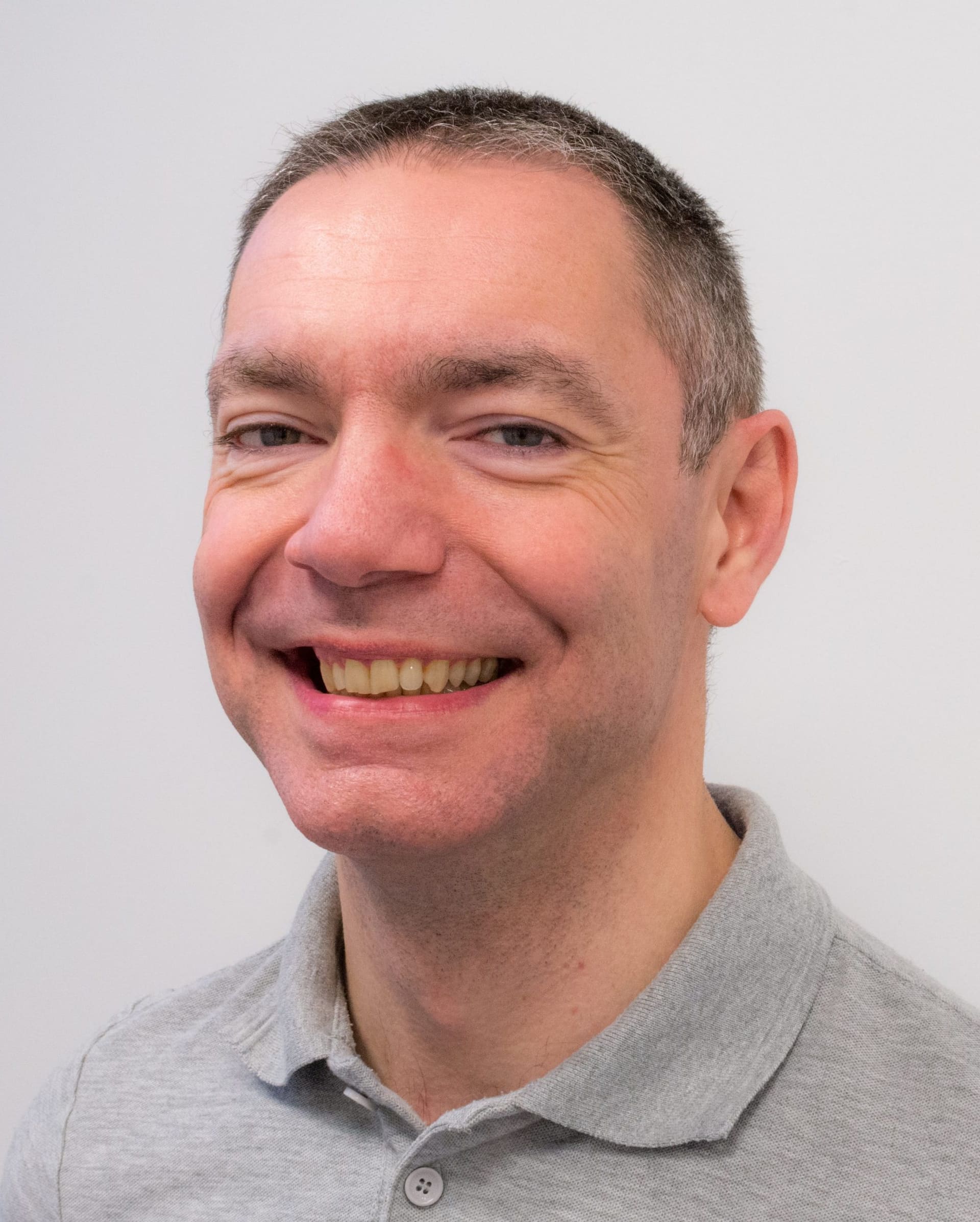 Teamlid van Fysiotherapie De Dijken, portret tegen een lichte wand.