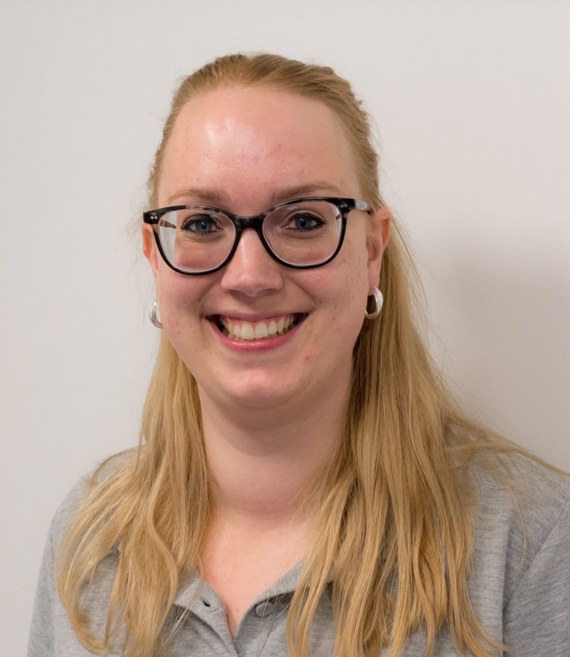 Teamlid van Fysiotherapie De Dijken, portret tegen een lichte wand.